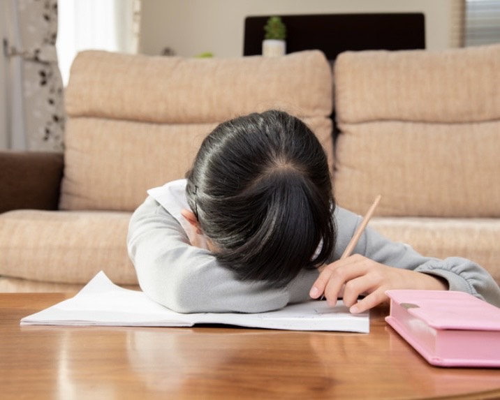 机に伏せている子ども